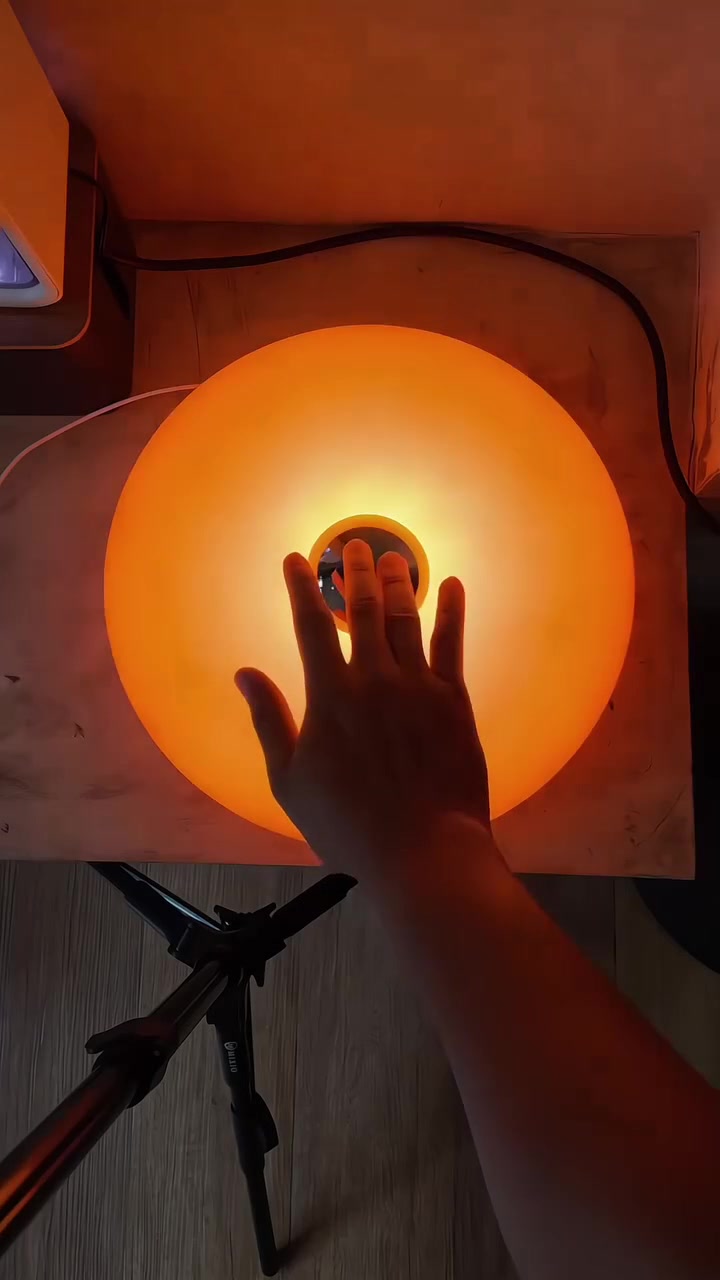 Mão tocando o centro da Luminária Donut