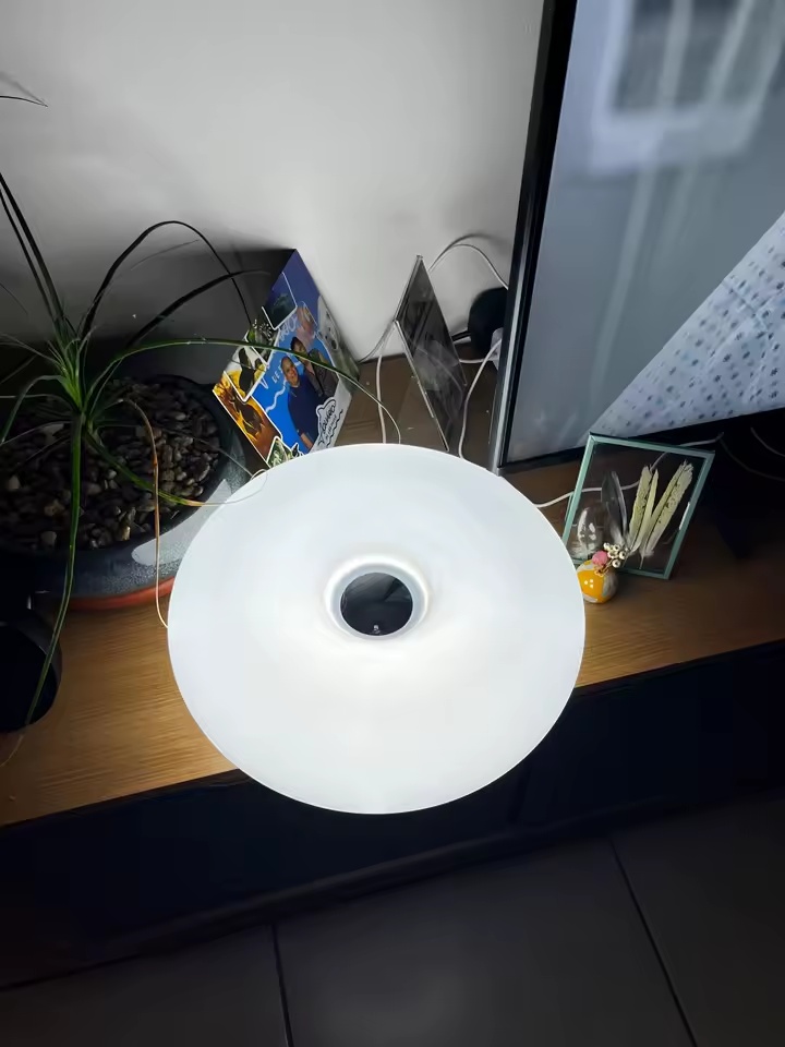 Luminária Donut branca acesa sobre móvel