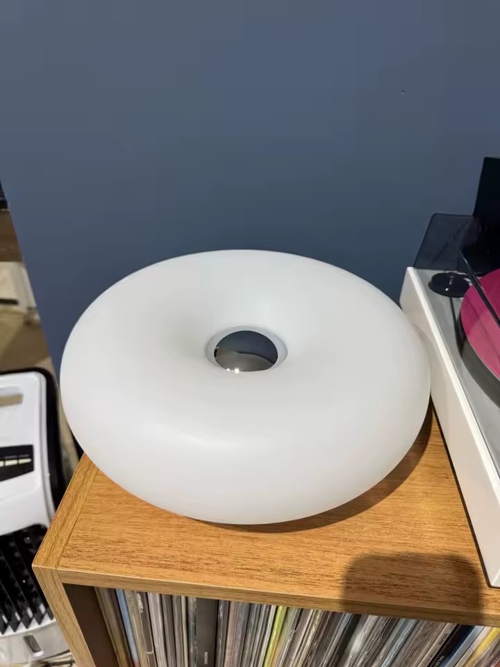 Luminária Donut branca desligada sobre prateleira